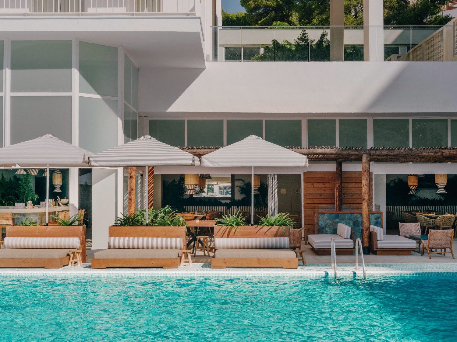 some bali sunbeds around the pool with the sun umbrellas open