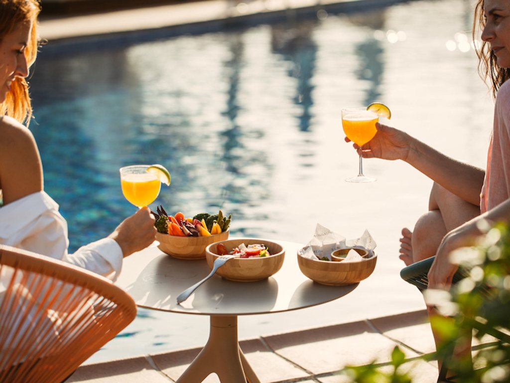 friends drinking cocktails by the poolside at Hyde Ibiza.